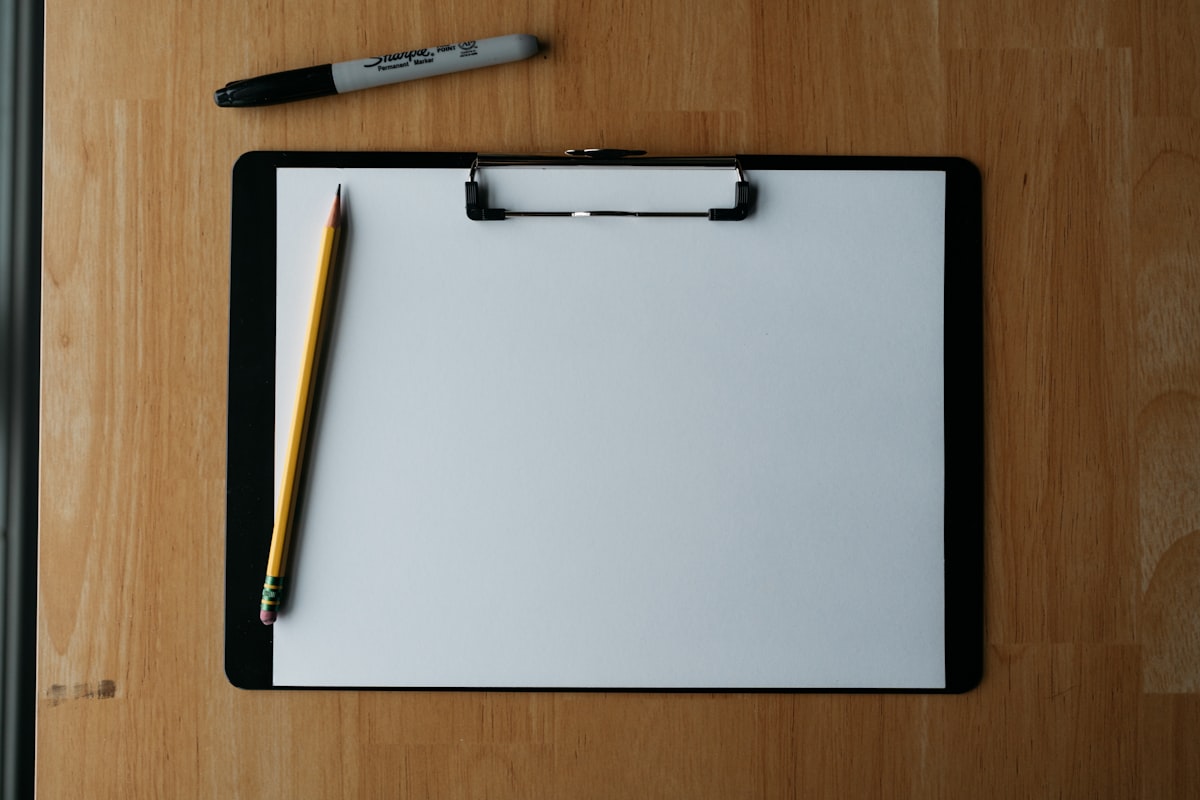 A clipboard with an intake assessment form, pencil, and pen on a clinician's desk.