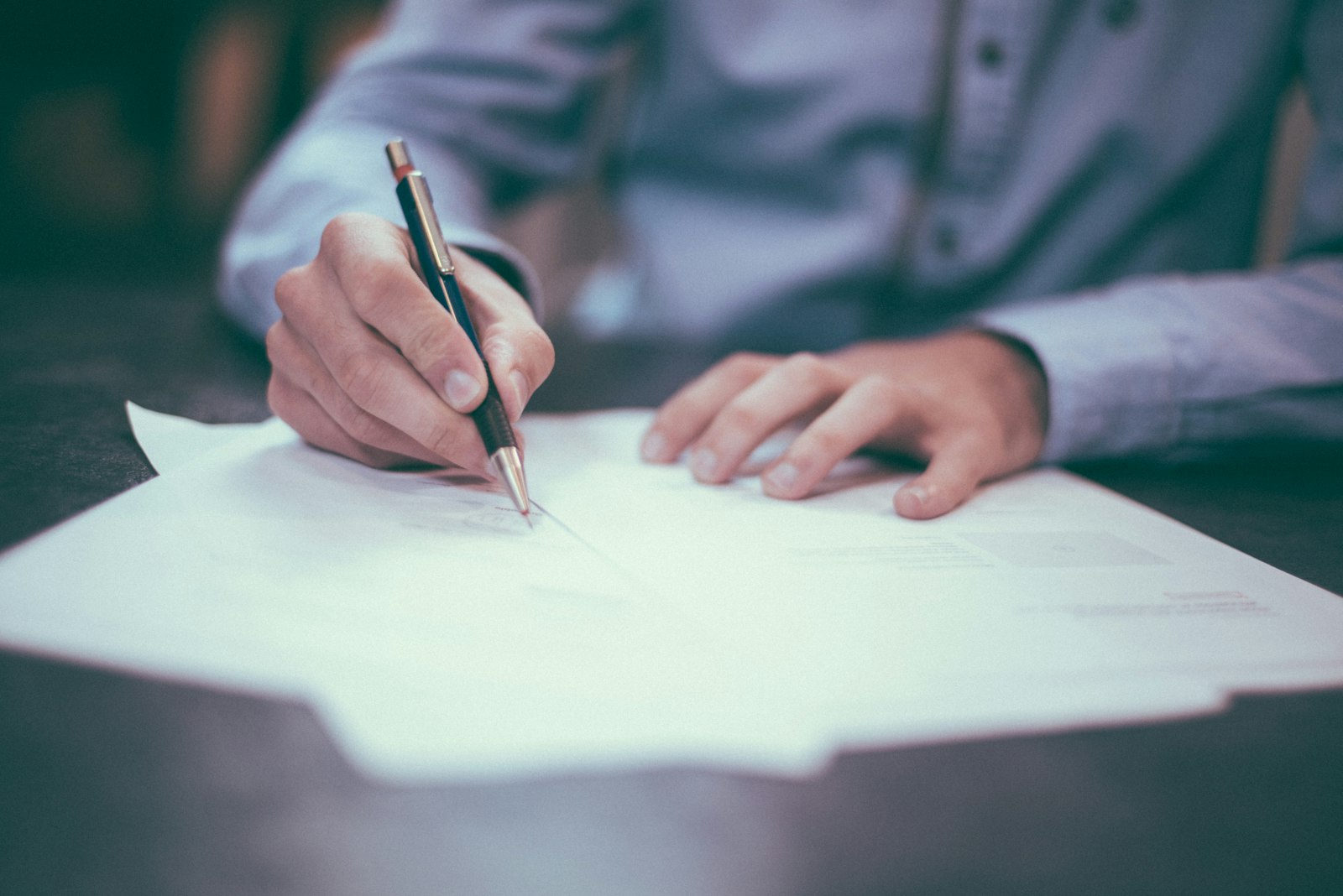 A California behavioral health compliance professional reviewing a licensing document at a desk