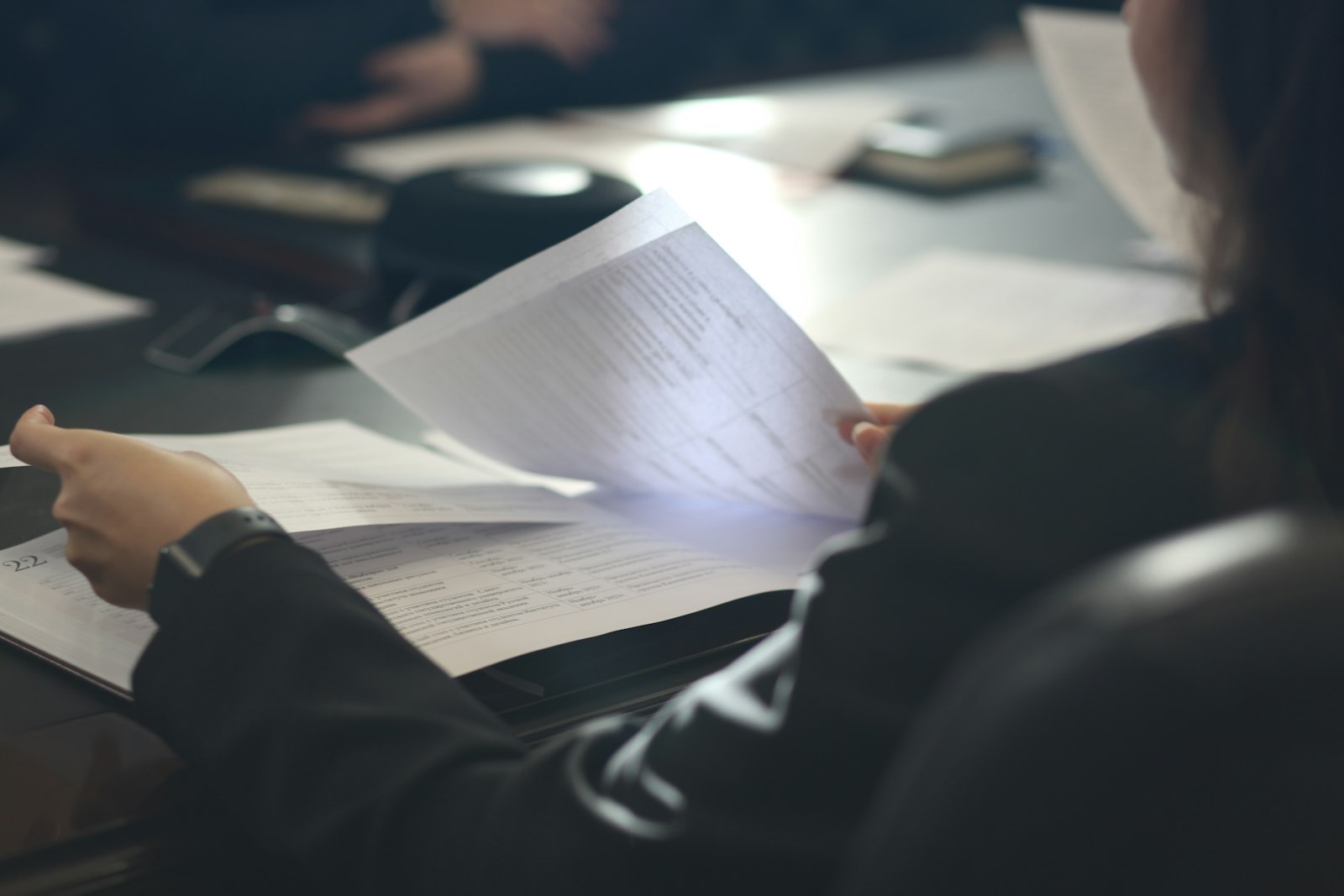 A reviewer seated at an office table reads through program documents during a readiness review.